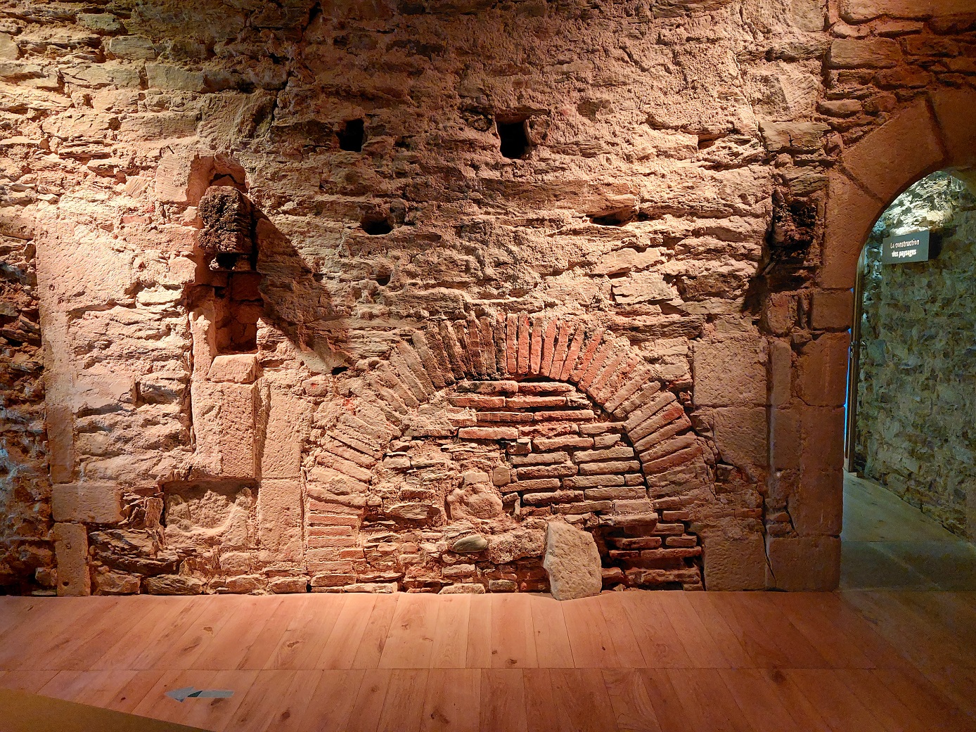 Former kitchen of old stone building in French village of Najac, showing position of former fireplace blocked up with old red bricks. 